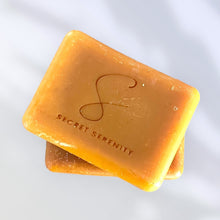 Load image into Gallery viewer, Two bars of orange soap with 'Secret Serenity' branding on a white background